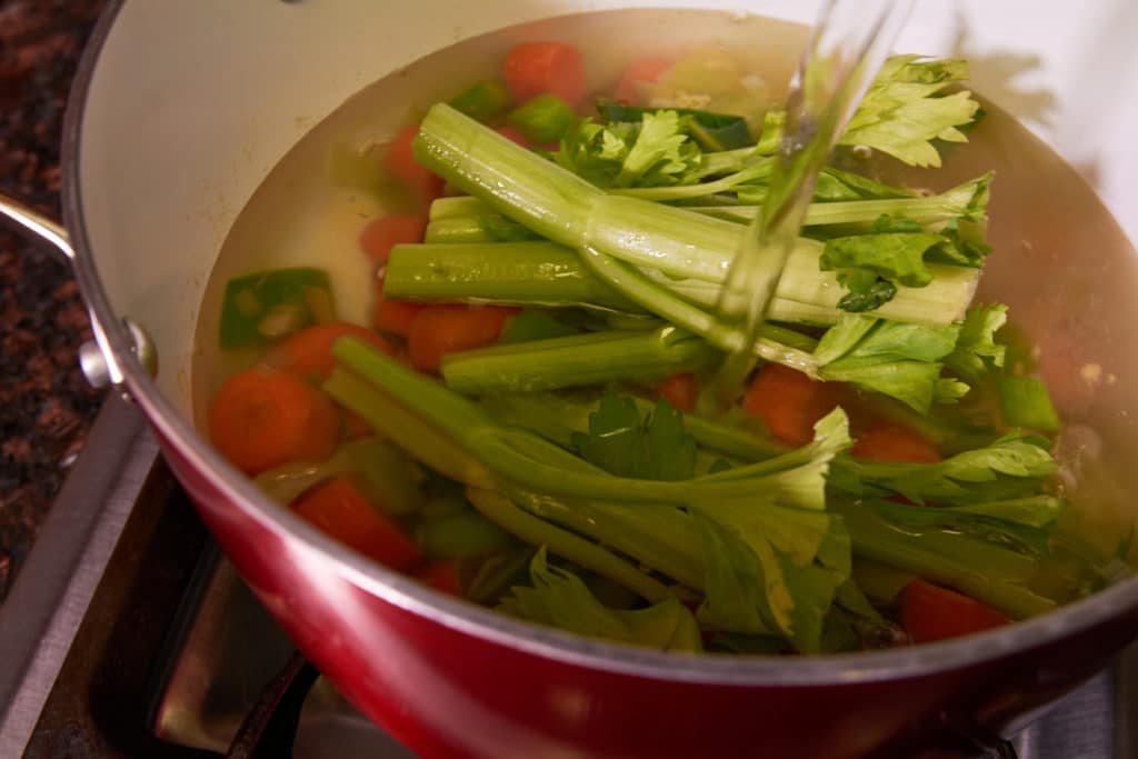 Adding water to a pot of veggies 