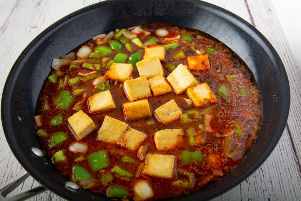 Cooked ingredients with sauce in a pan.  