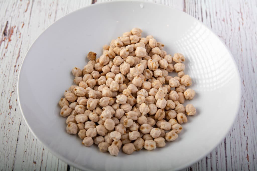 Dried chickpeas in a bowl sitting on a table.
