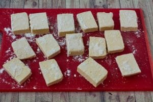 Tofu sprinkled with cornstarch on a cutting board