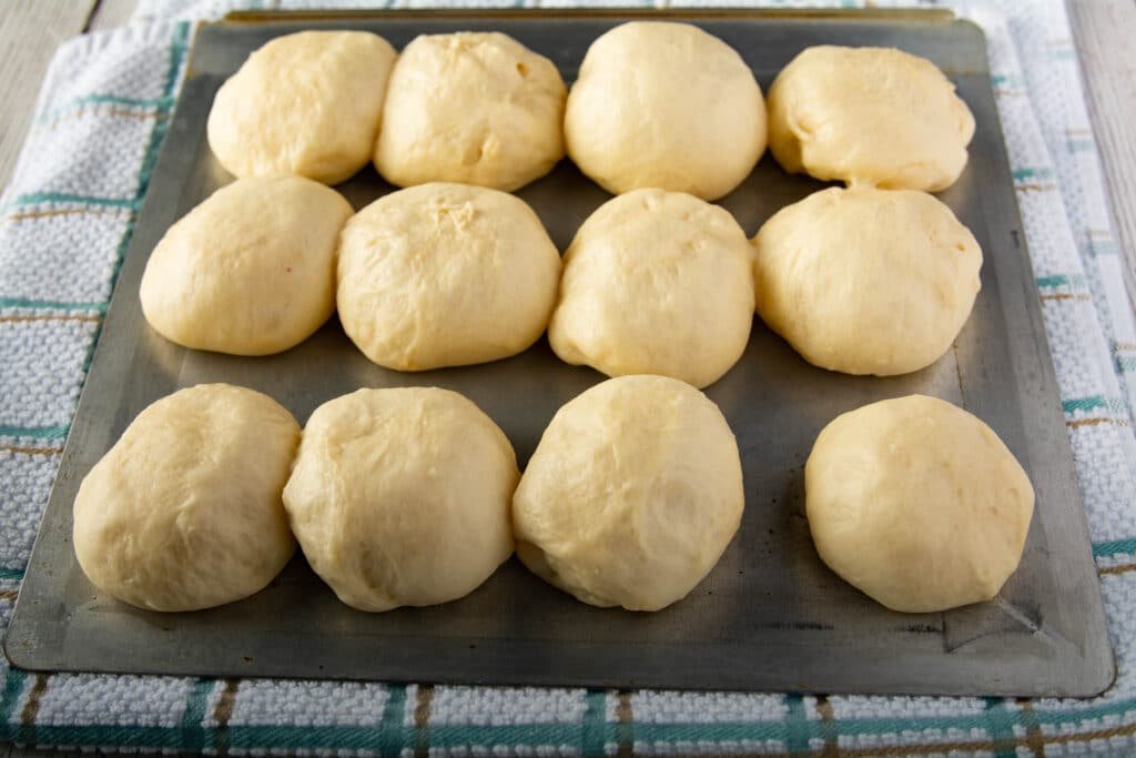 Balls of dough on a cookie sheet after rising