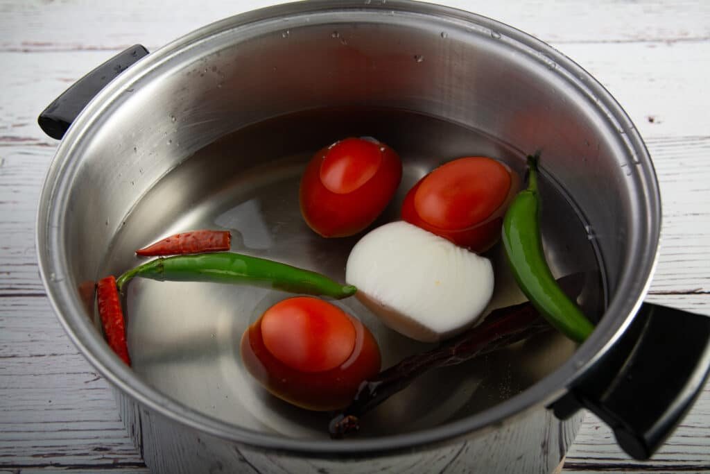 Pot with water covering salsa ingredients