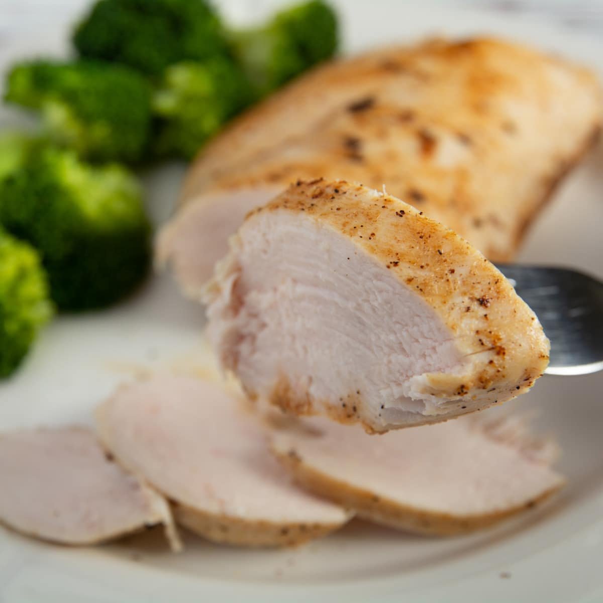 A slice of cooked chicken on a fork