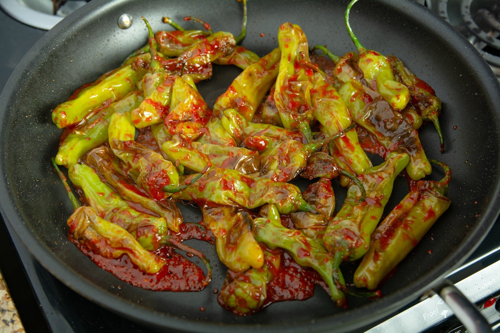 Fried peppers in a pan with spicy sauce