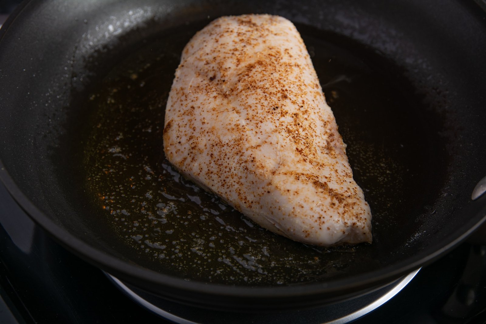 Raw seasoned chicken in a pan.