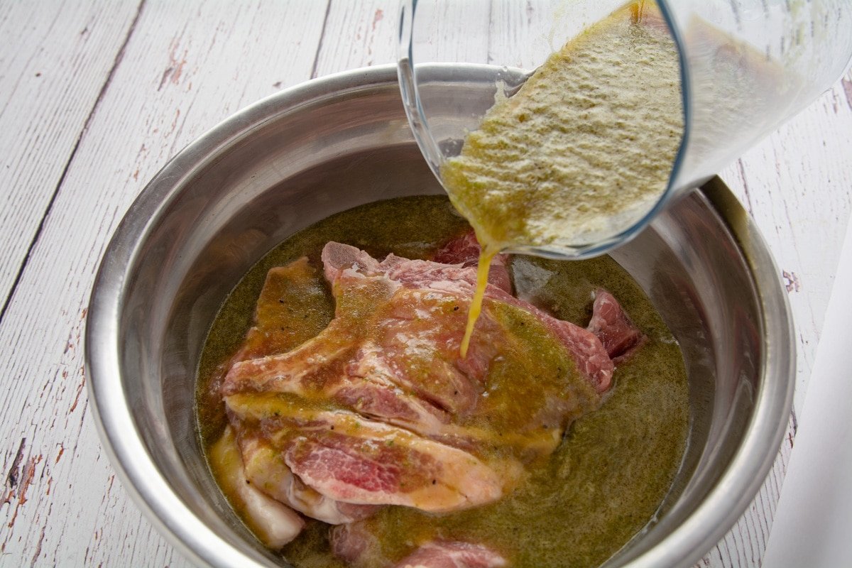 Pork steaks in a bowl with a picture pouring the marinade onto the steaks