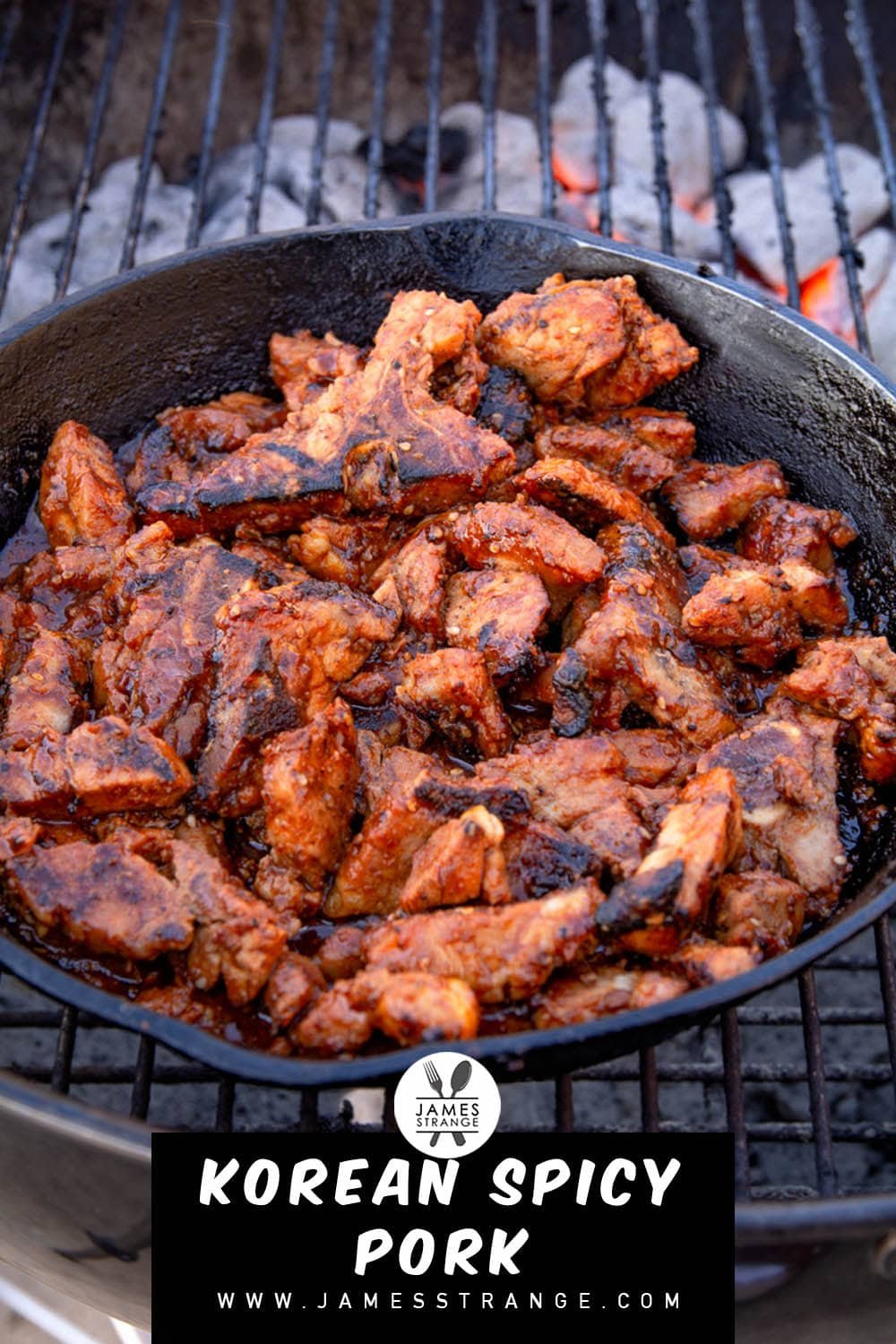 Spicy pork in a cast iron pan cooking on a grill. This is a pin for pinterest