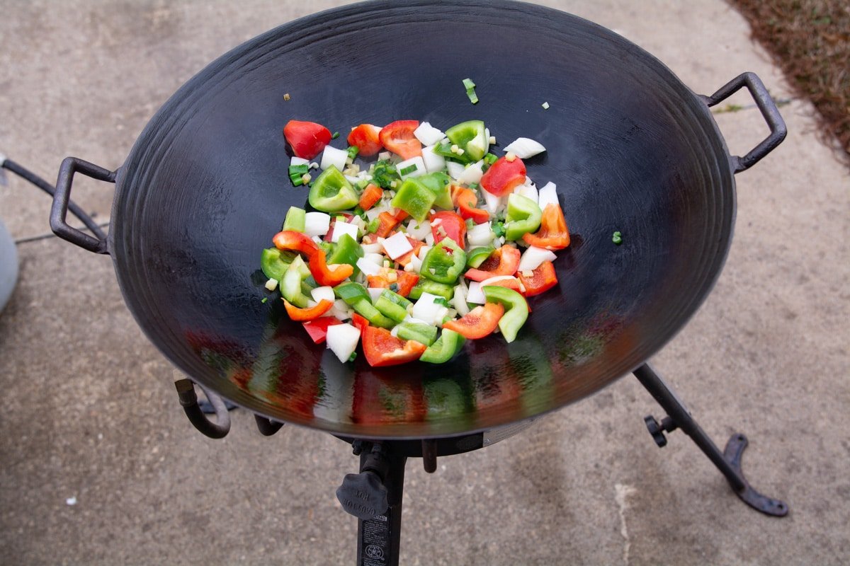 Bell peppers, green onion, garlic and ginger in a wok.