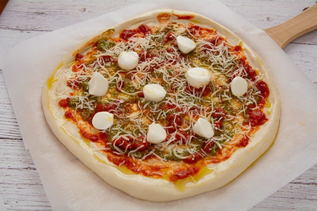 Pizza ready for the oven on parchment paper