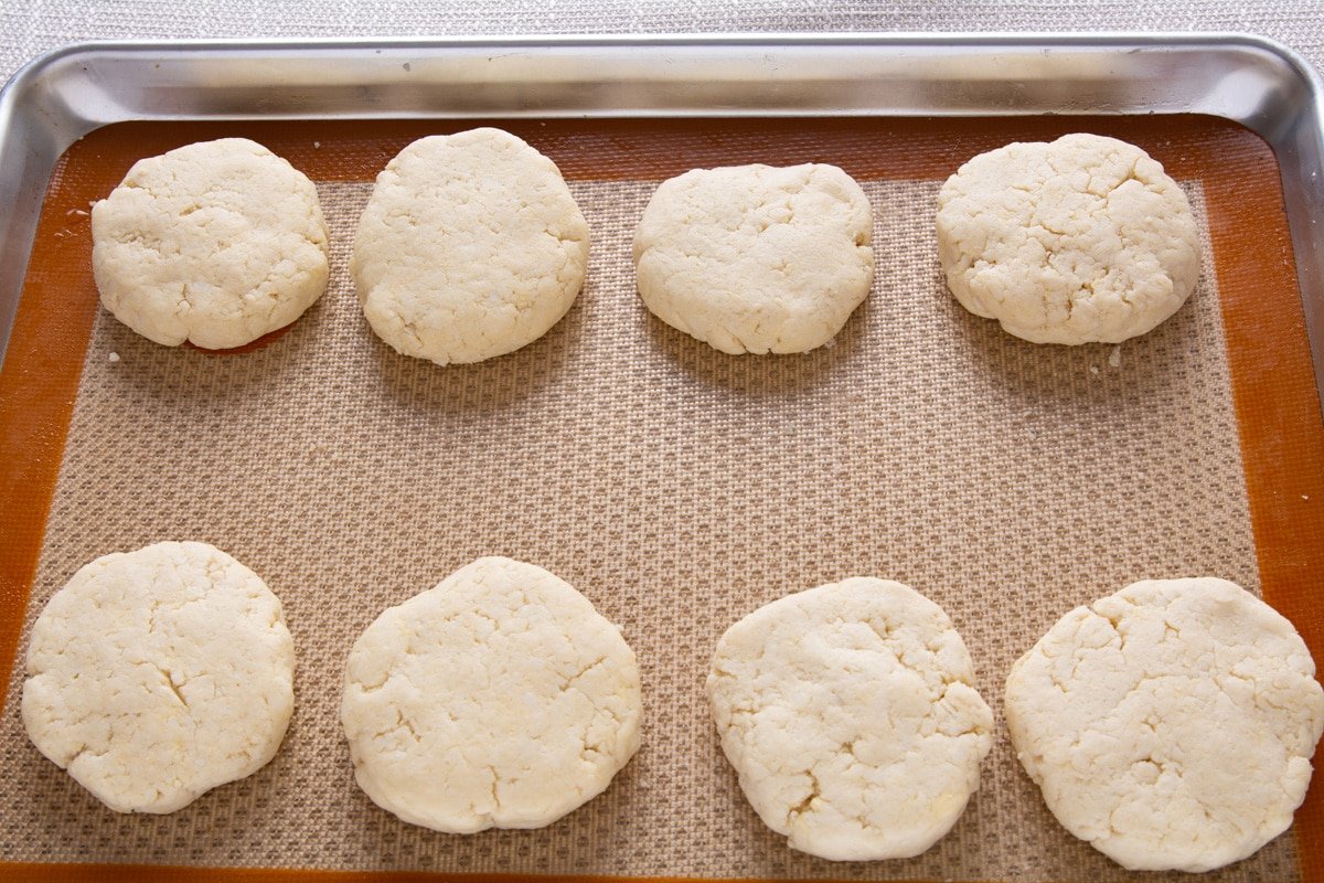 8 raw biscuits on a baking tray
