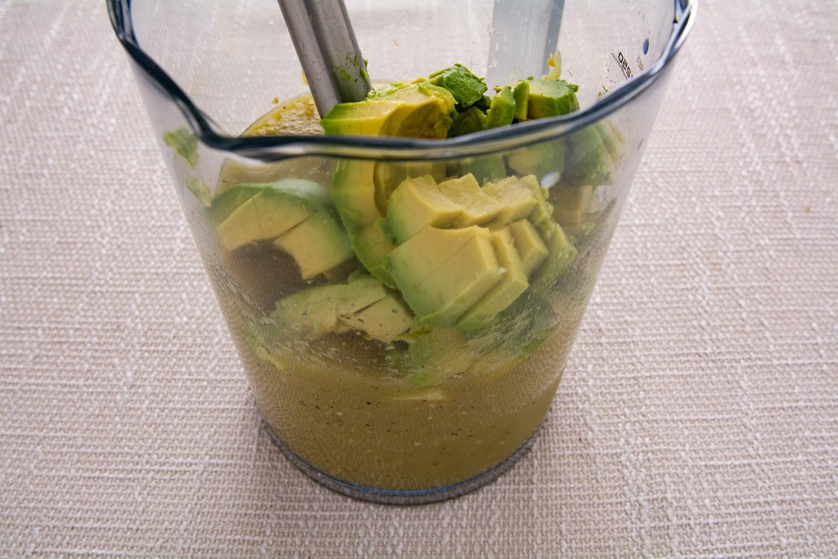 Salsa in a blender container with avocado.