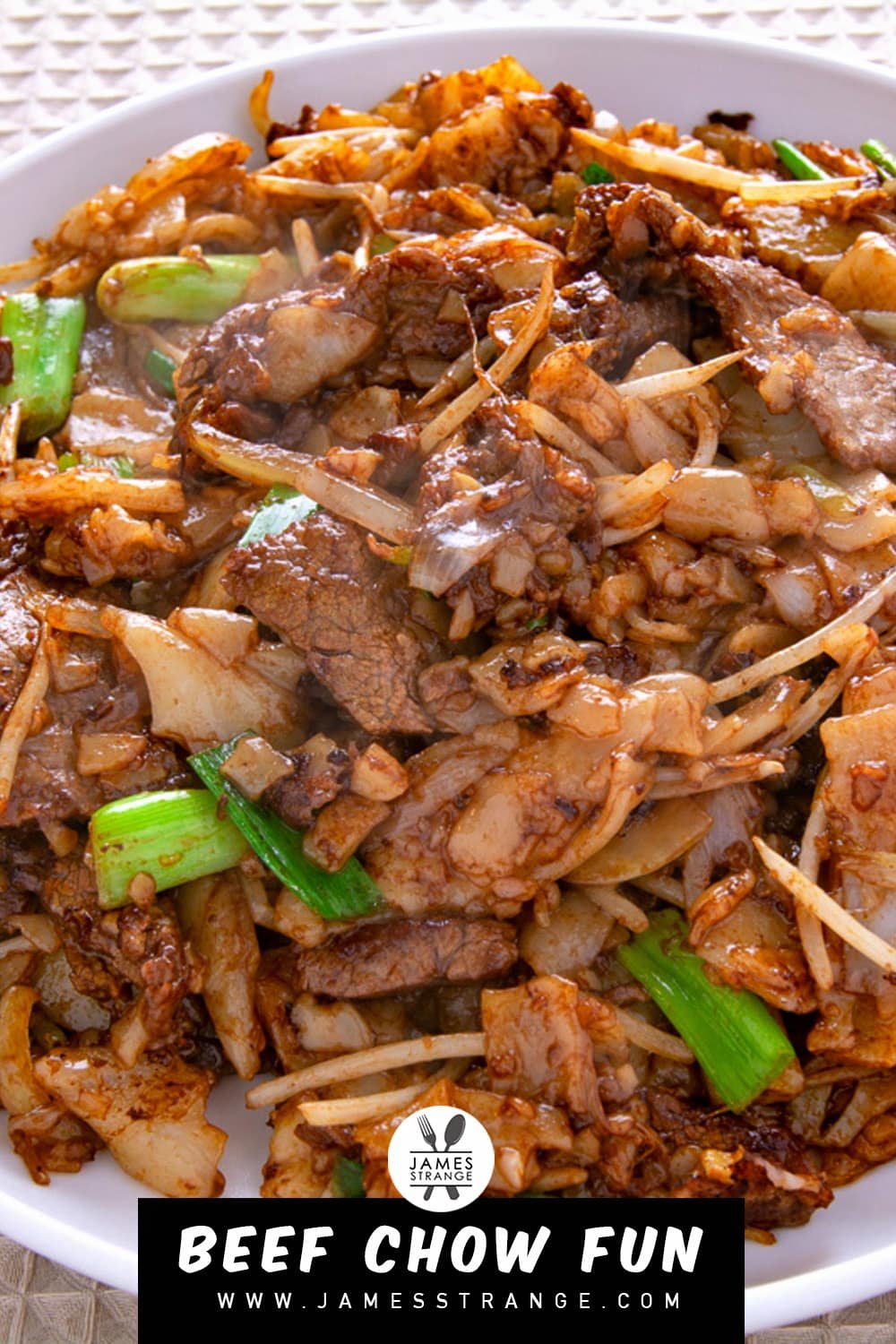 Plate of beef chow fun on a table, this is a pin for Pinterest