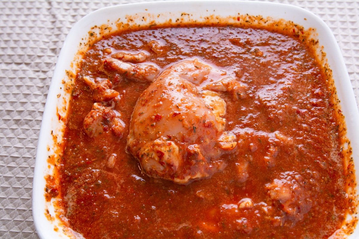 Chicken marinating in a spicy sauce