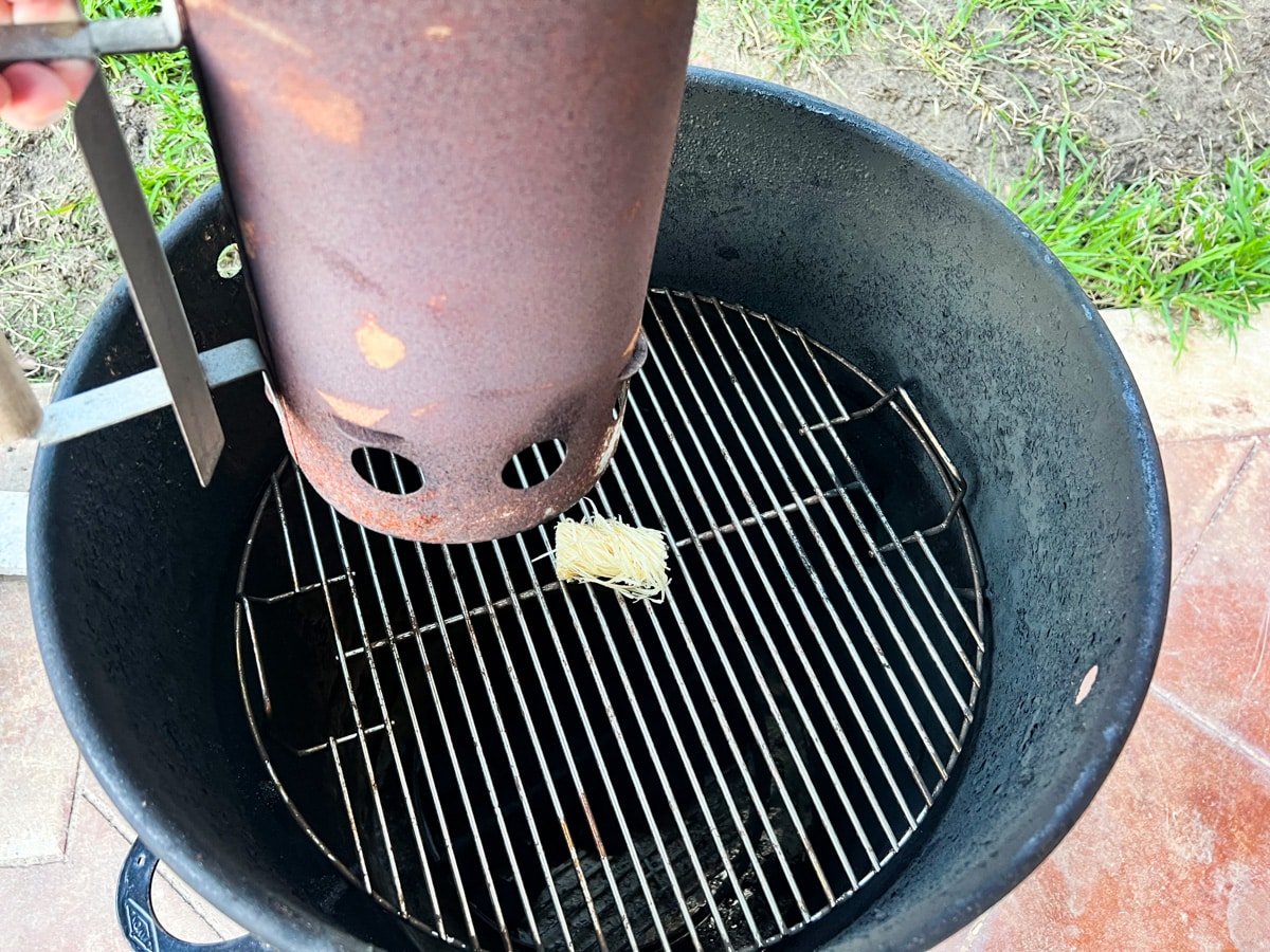 A Charcoal chimney on a grill with a fire starter