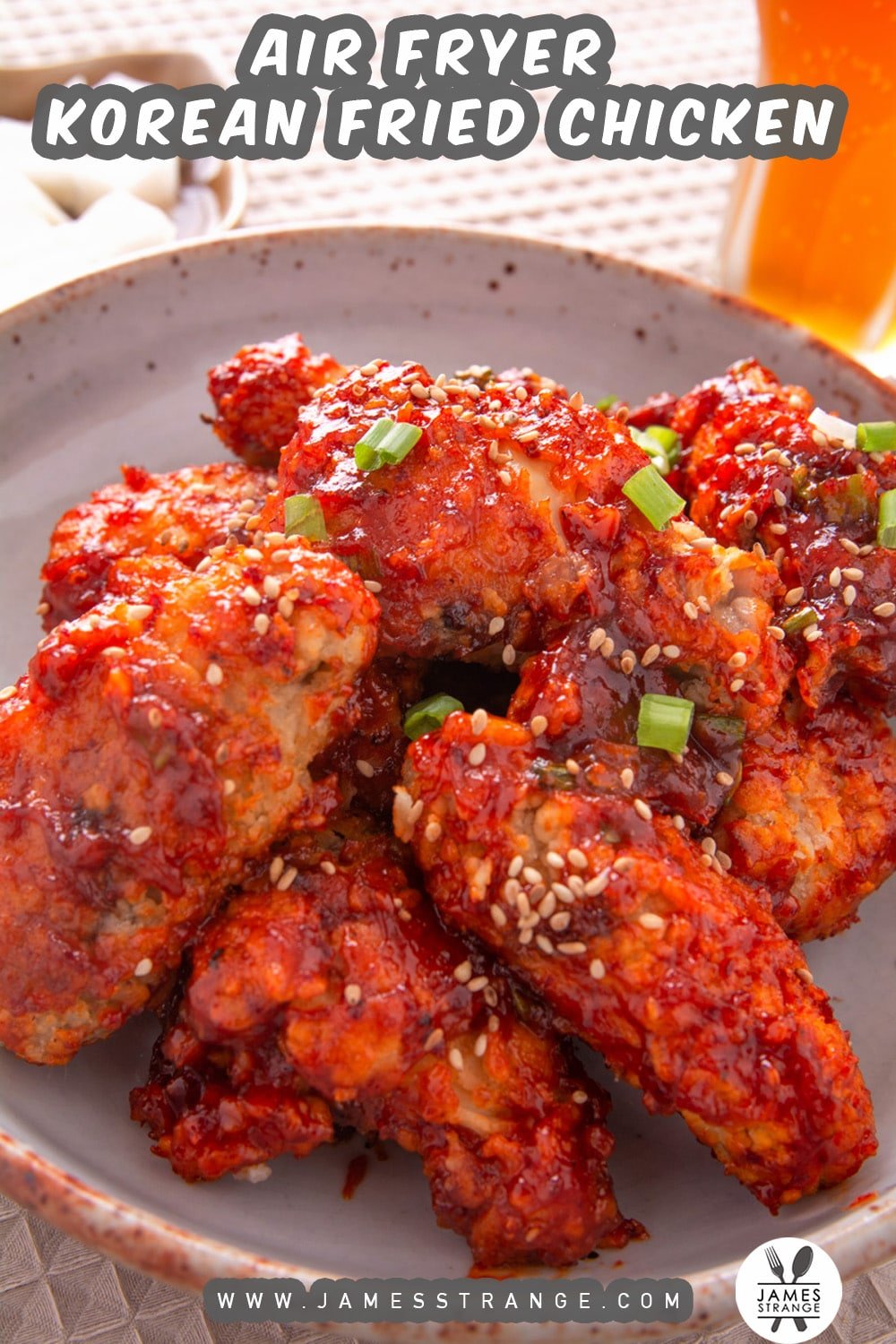 Plate a spicy Korean fried chicken wings with beer and pickled radish in the background. This is a pin for Pinterest