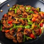 Seitan and vegetables in a spicy sauce in a pan.