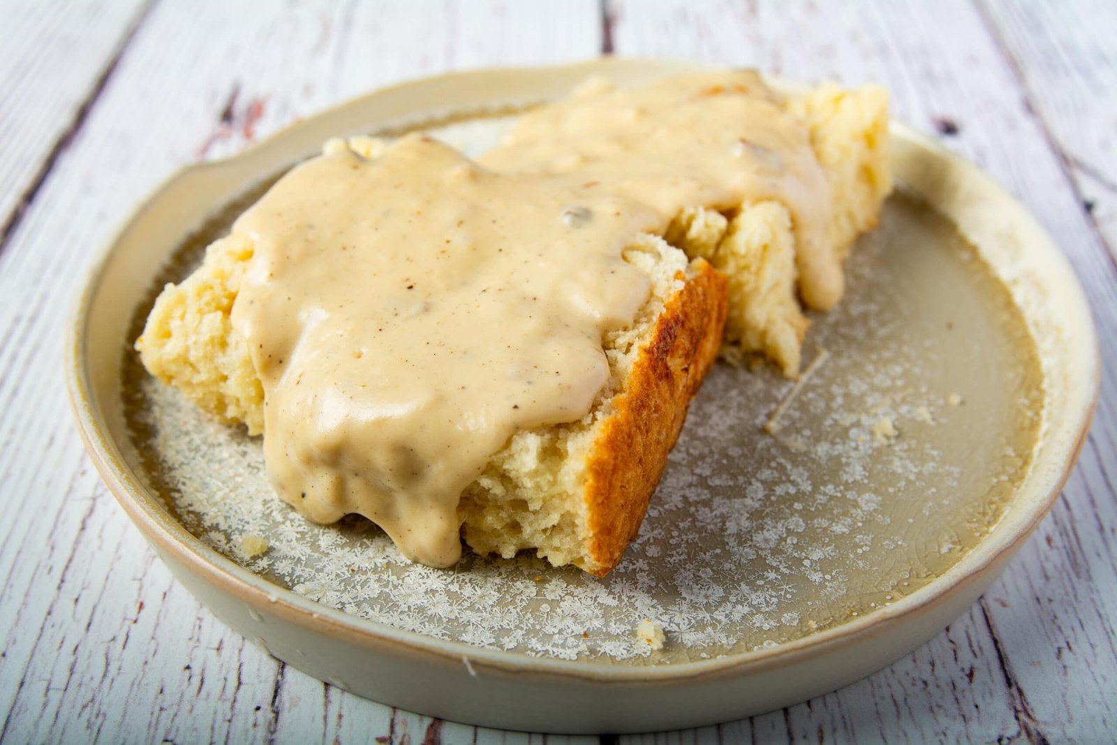 Vegan gravy over a biscuit on a plate