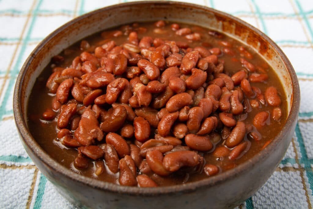 Cooked red beans in a bowl sitting on a towel.