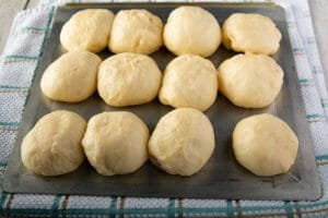 Balls of dough on a cookie sheet after rising