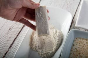 First step of dredging tofu, showing the tofu with flour.