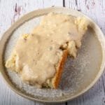 Vegan gravy over a biscuit on a plate