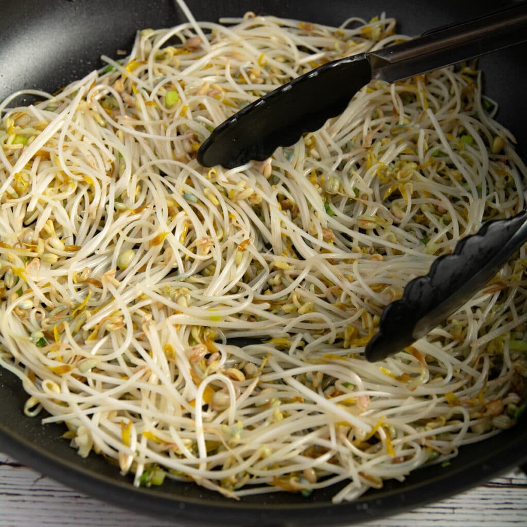 Finished dish of stir fried bean sprouts in a pan.