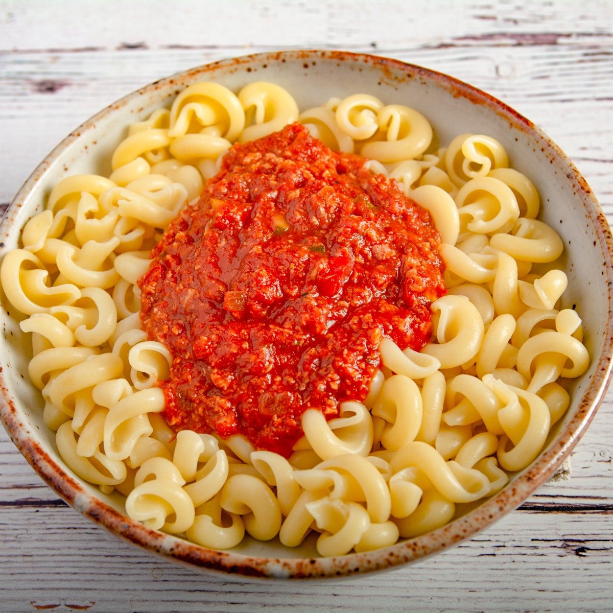 A bowl to pasta topped with sauce