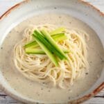 Small thin noodles in soy milk soup in a bowl.