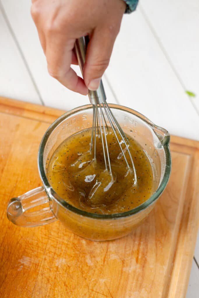 Dressing being whisked in a measuring cup
