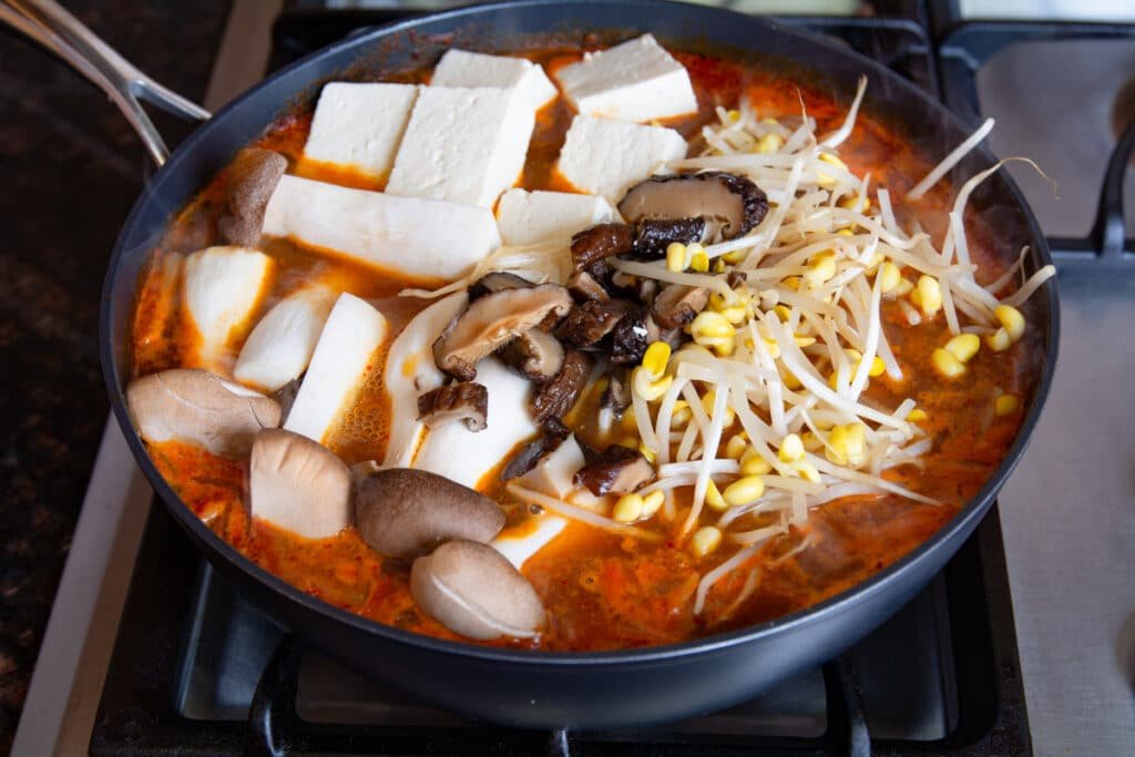 Spicy fish stew cooking on a stove.