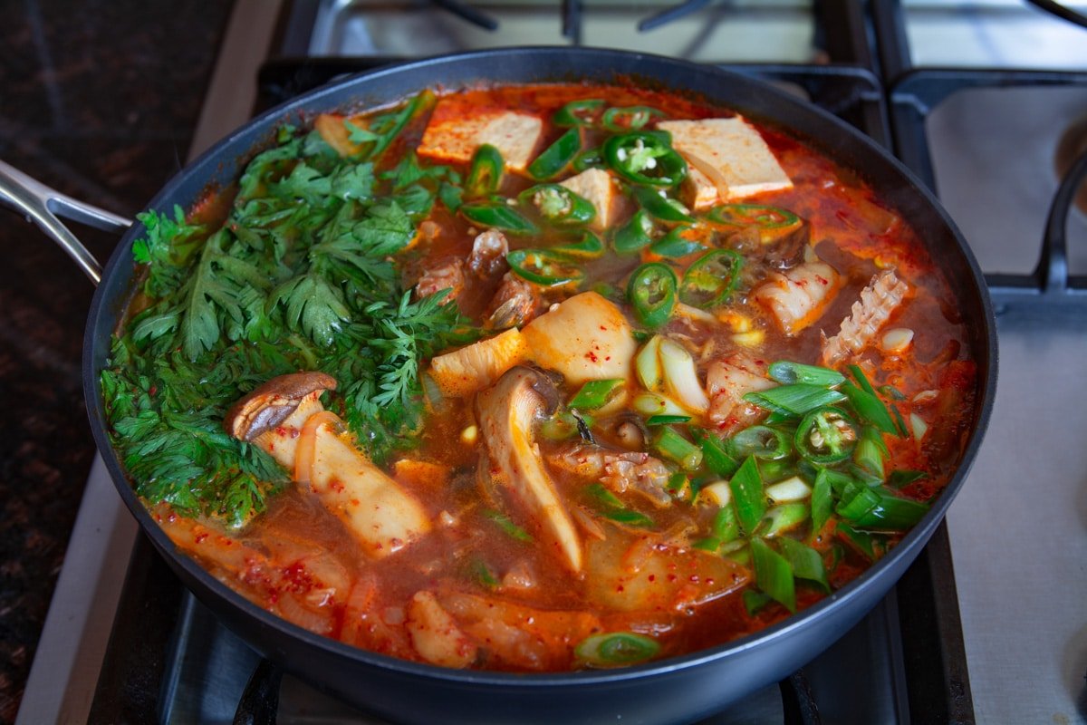 Spicy fish stew cooking on a stove.