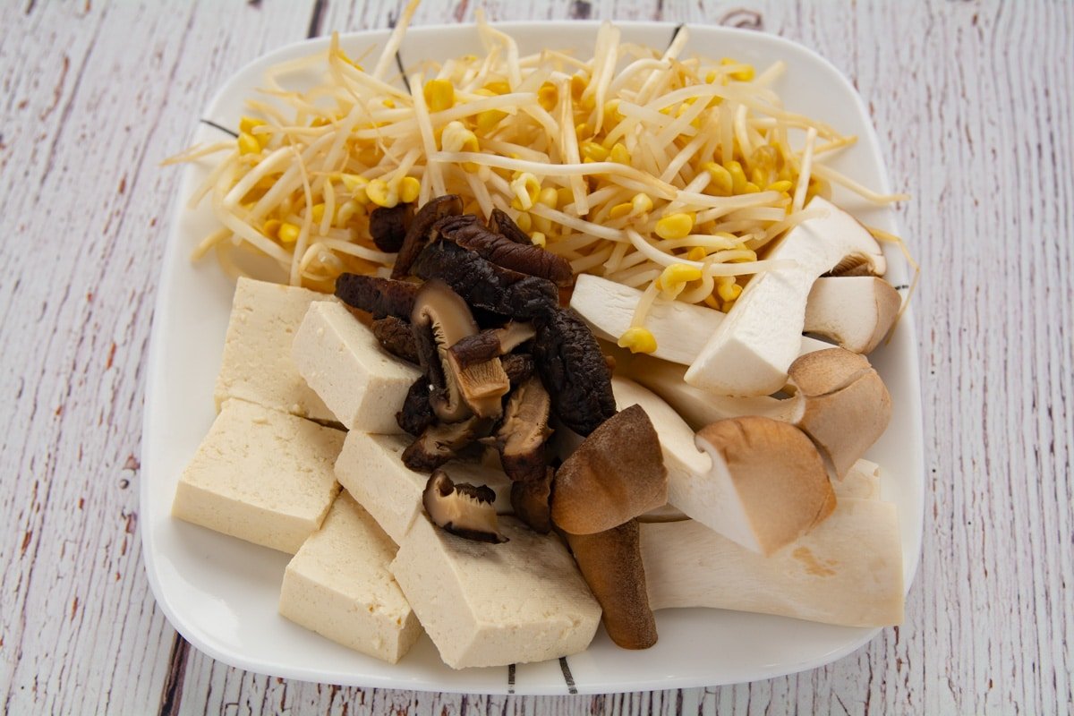 Soybean sprouts, mushrooms and tofu on a plate.