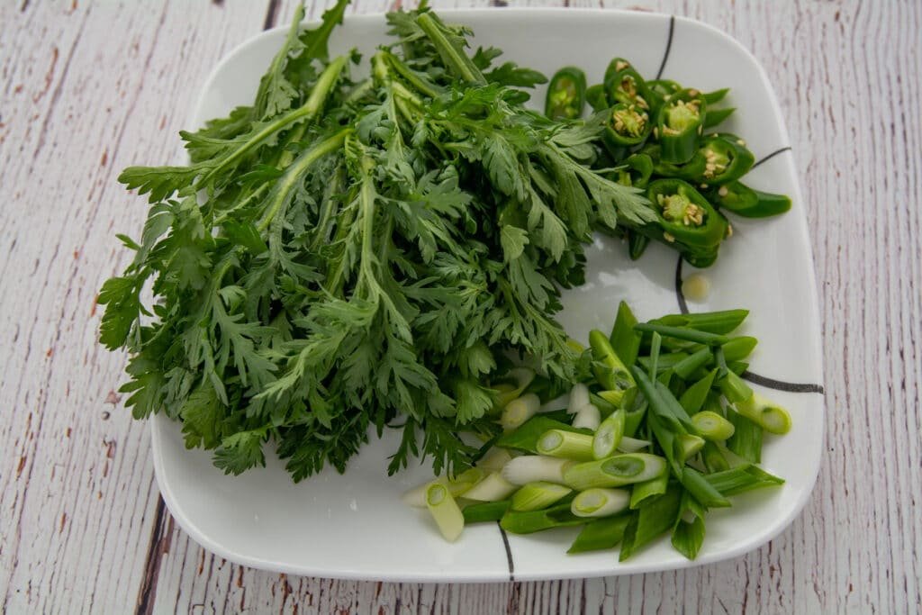 ssuk-gat (crown daisy), green peppers and green onion on a plate.