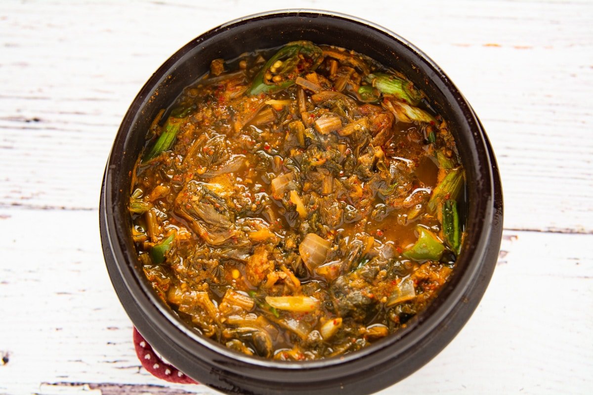 Ceramic bowl of Korean stew on a table.