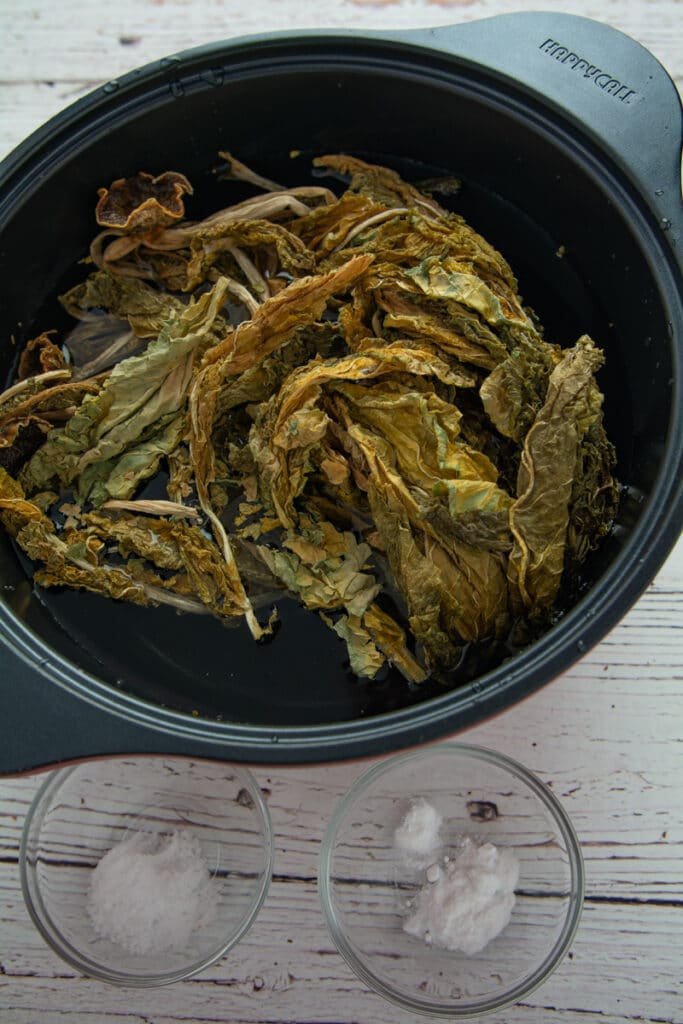 Dried radish leaves in a pot of water, Bowl of salt and bowl of baking soda
