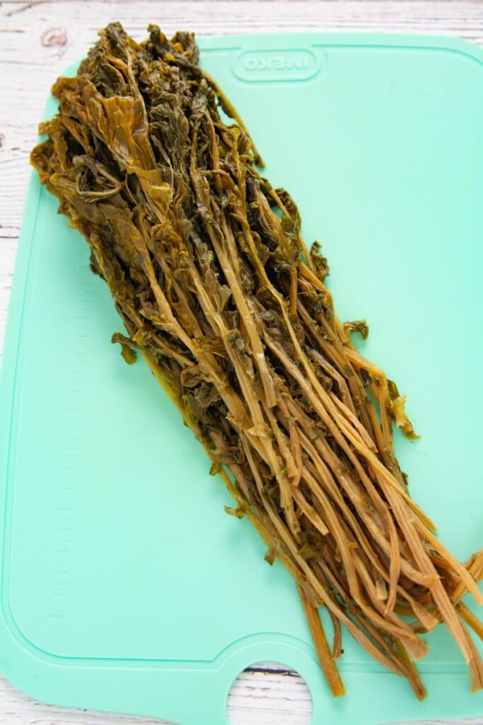 Dried radish stems on a cutting board after peeling