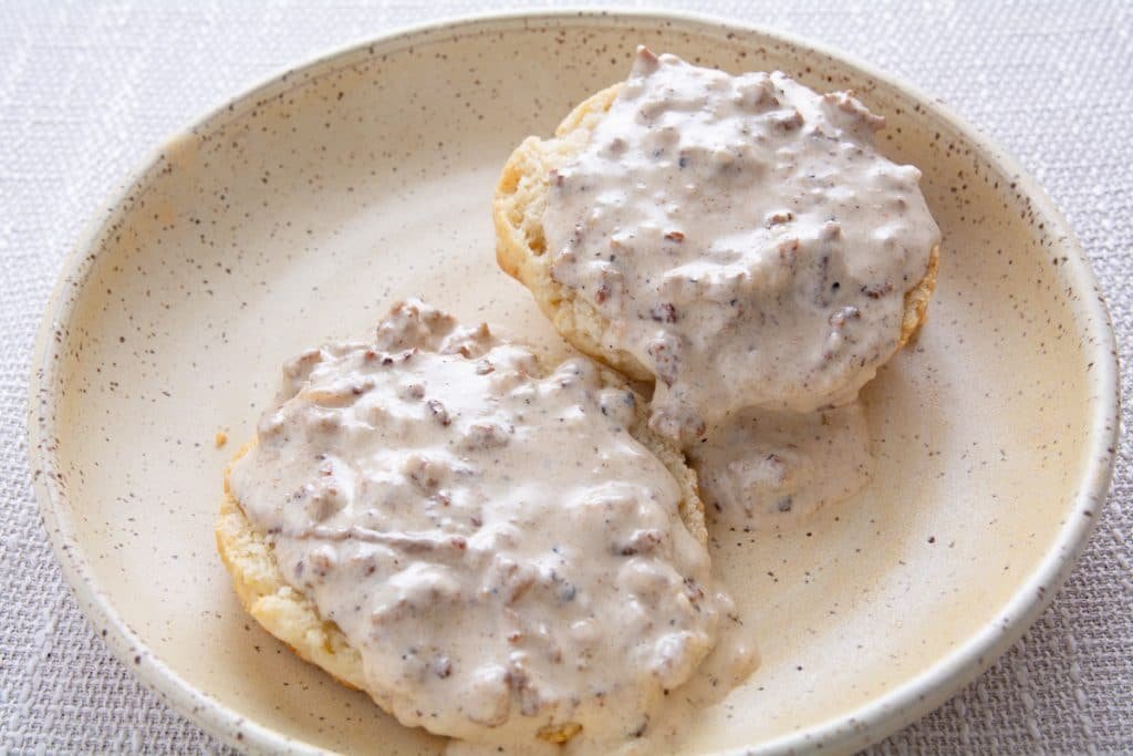 Biscuits covered in gravy on a plate