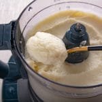 A spoon holding mashed cauliflower.