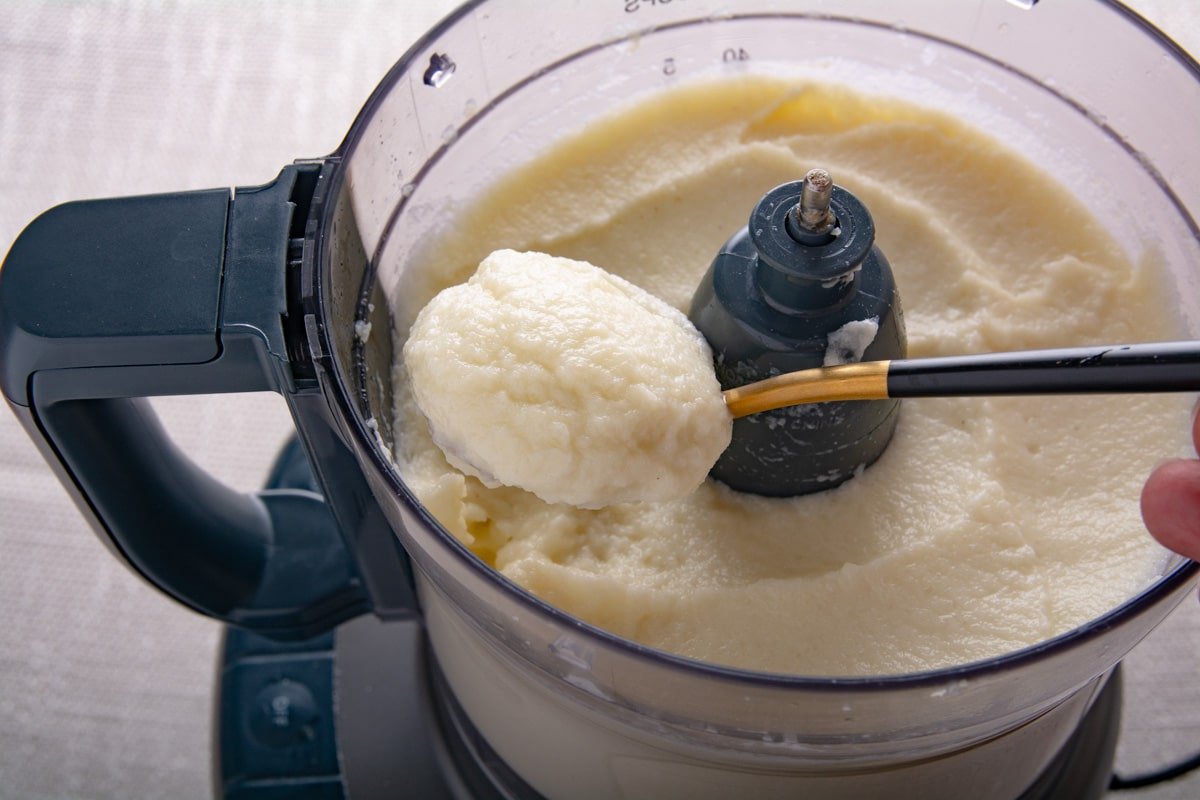 A spoon holding mashed cauliflower.