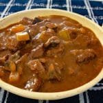 Bowl of beef stew on a table.