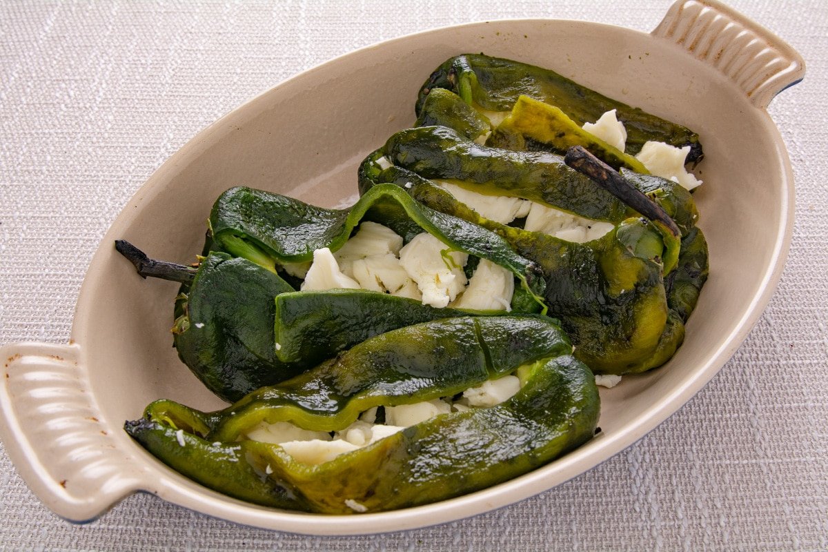 Poblano peppers stuffed with cheese in a pan