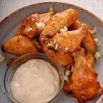 Cooked wings on a plate with dipping sauce