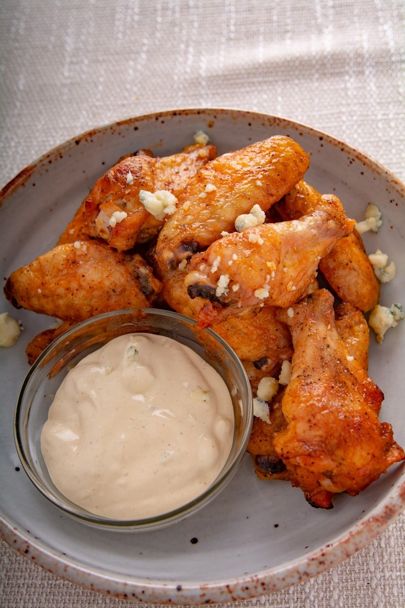 Cooked wings on a plate with dipping sauce