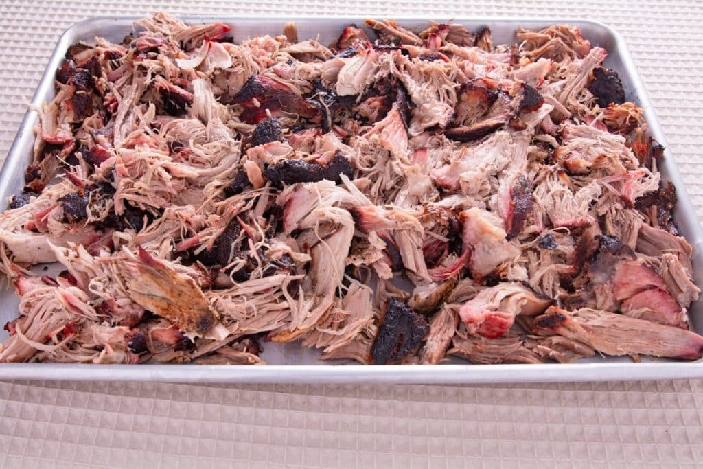 Cooked pulled pork on a tray.