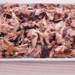 Cooked pulled pork on a tray.