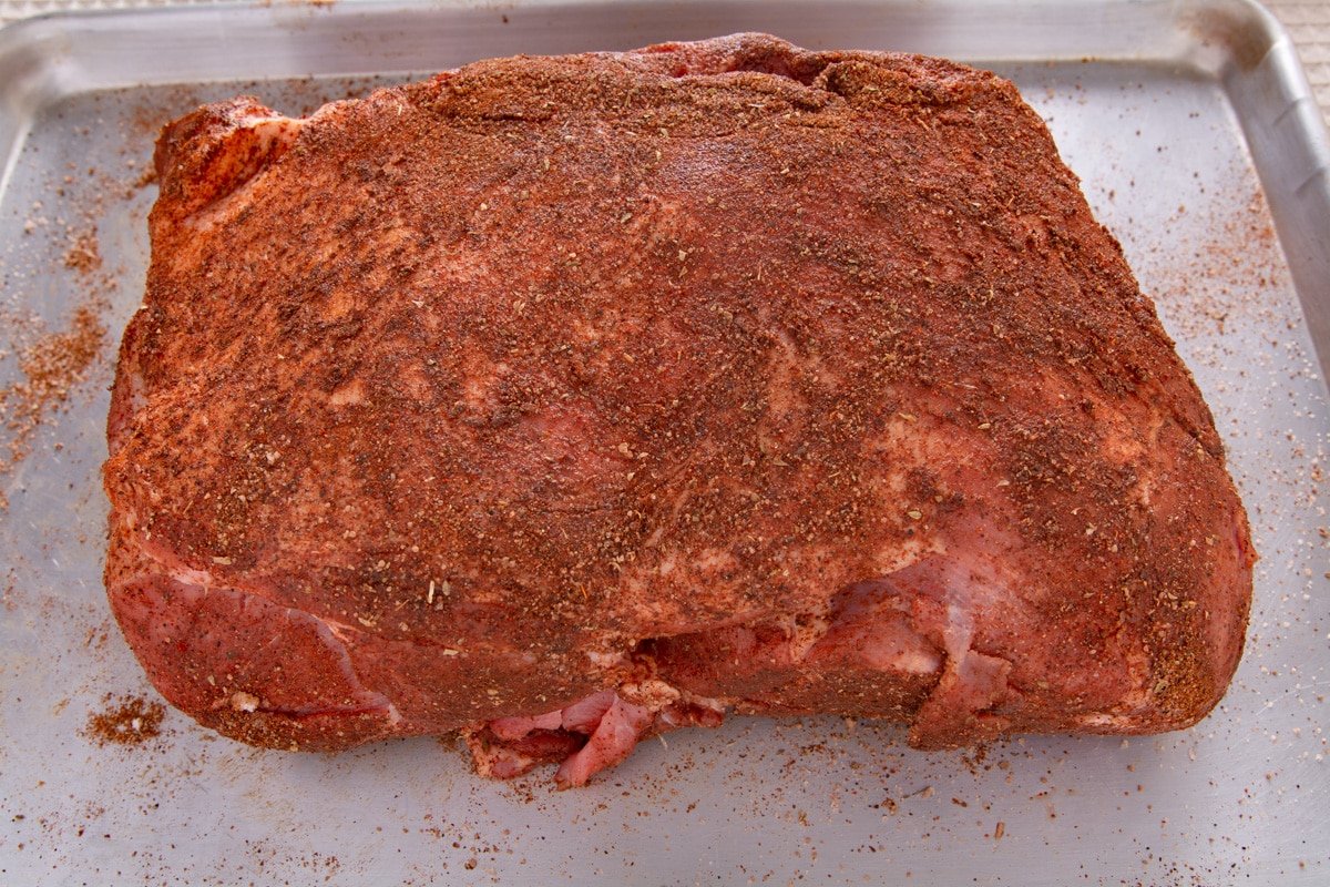 Seasoned boneless pork shoulder on a tray