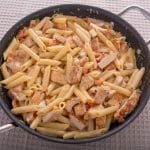 Chicken and pasta with a cream sauce in a pan.