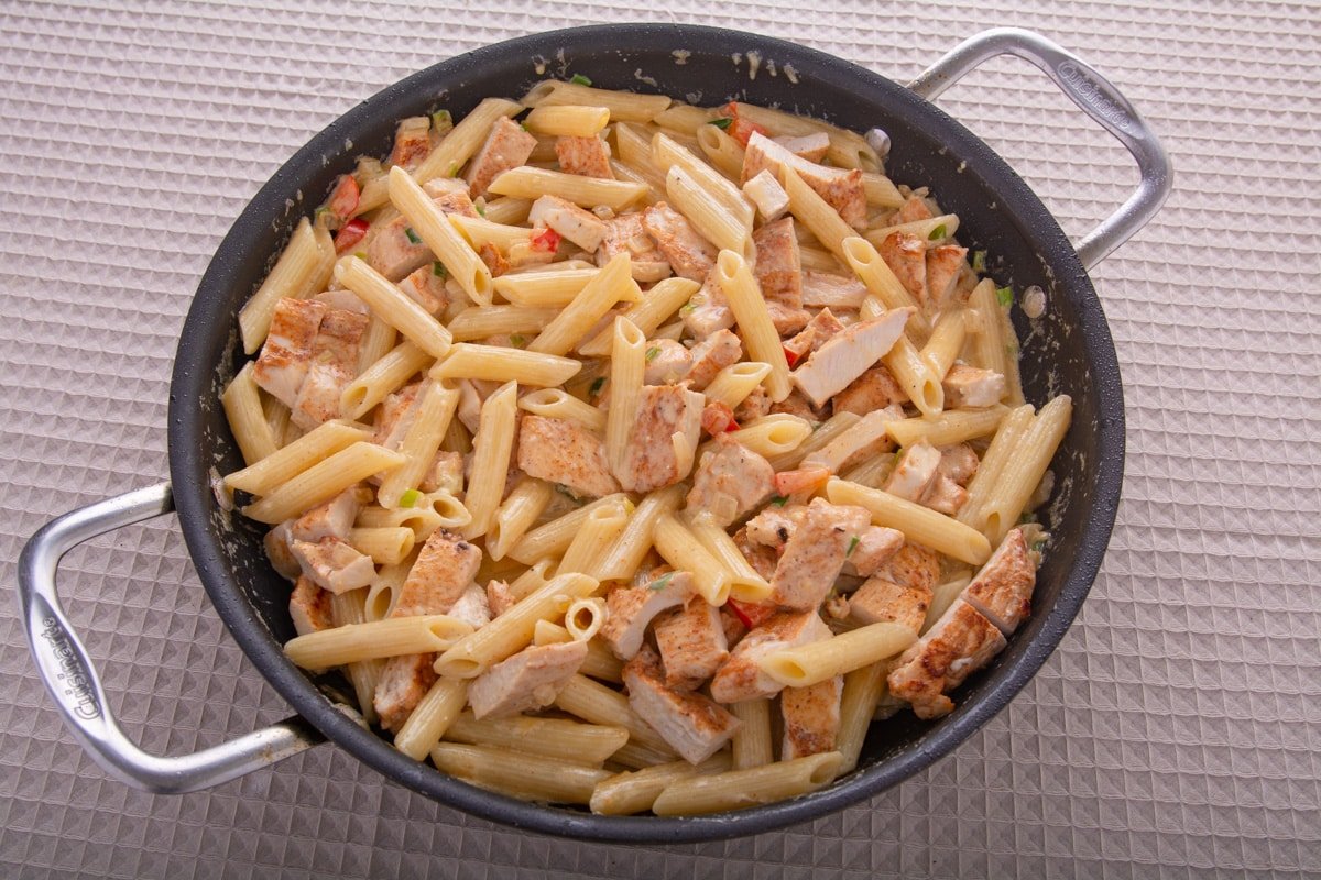 Chicken and pasta with a cream sauce in a pan.