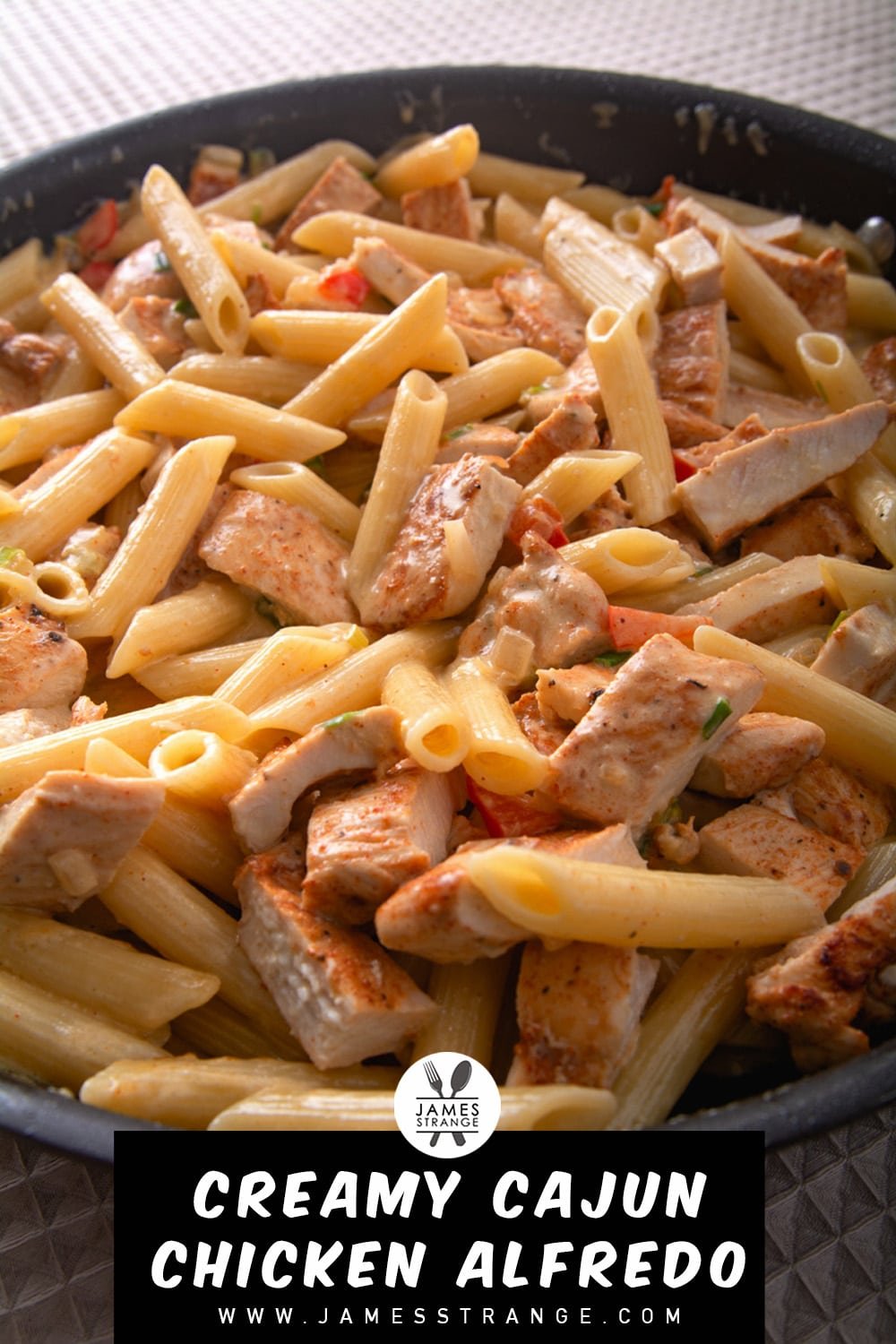 Chicken and pasta with a cream sauce in a pan. This is a pin for Pinterest