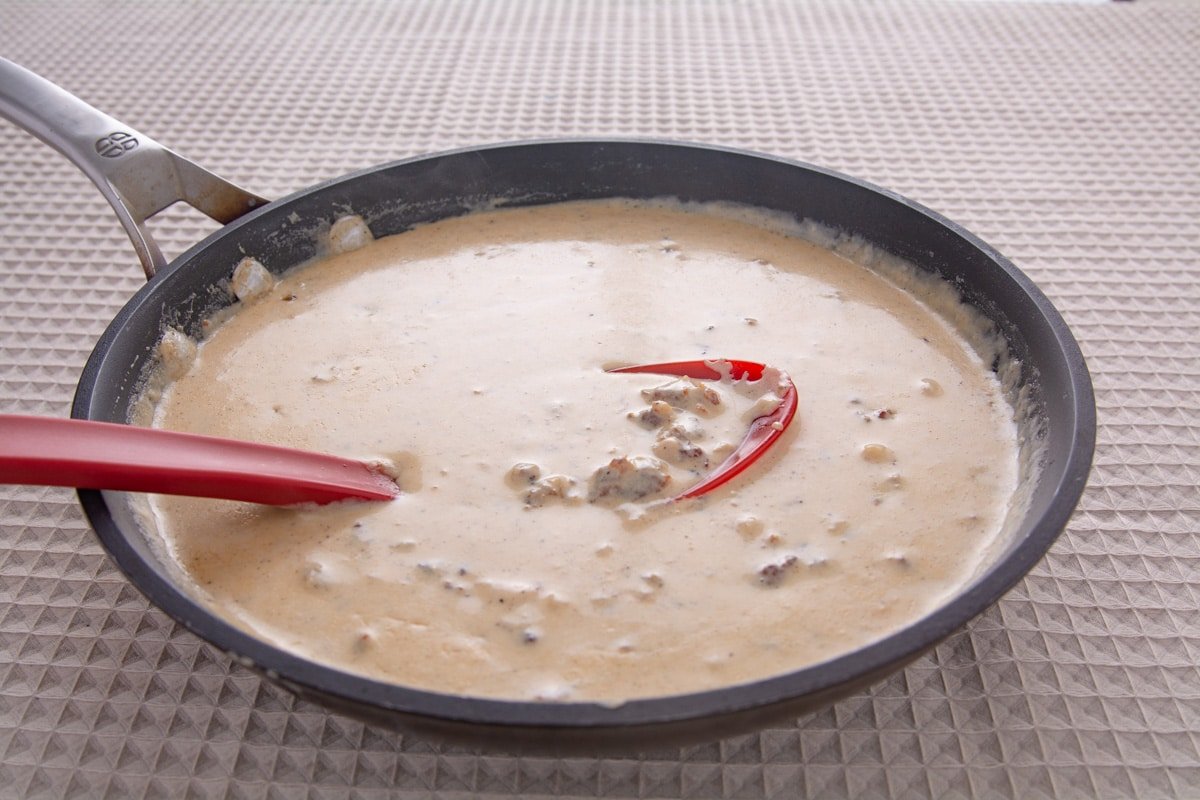 Pan of white gravy with a spoon.